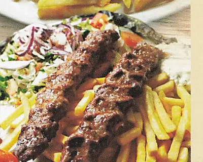 Adana-Spieße vom Holzkohlengrill mit Pommes und Salat